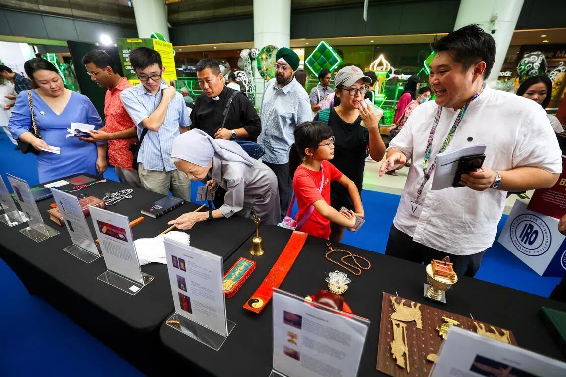 宗教和谐联欢日为期两天，现场设有五个不同主题的互动展区。公众可免费参观展览、尝试数码屏幕上的问答题，或与义工交流，了解本地10个宗教。（林明顺摄）