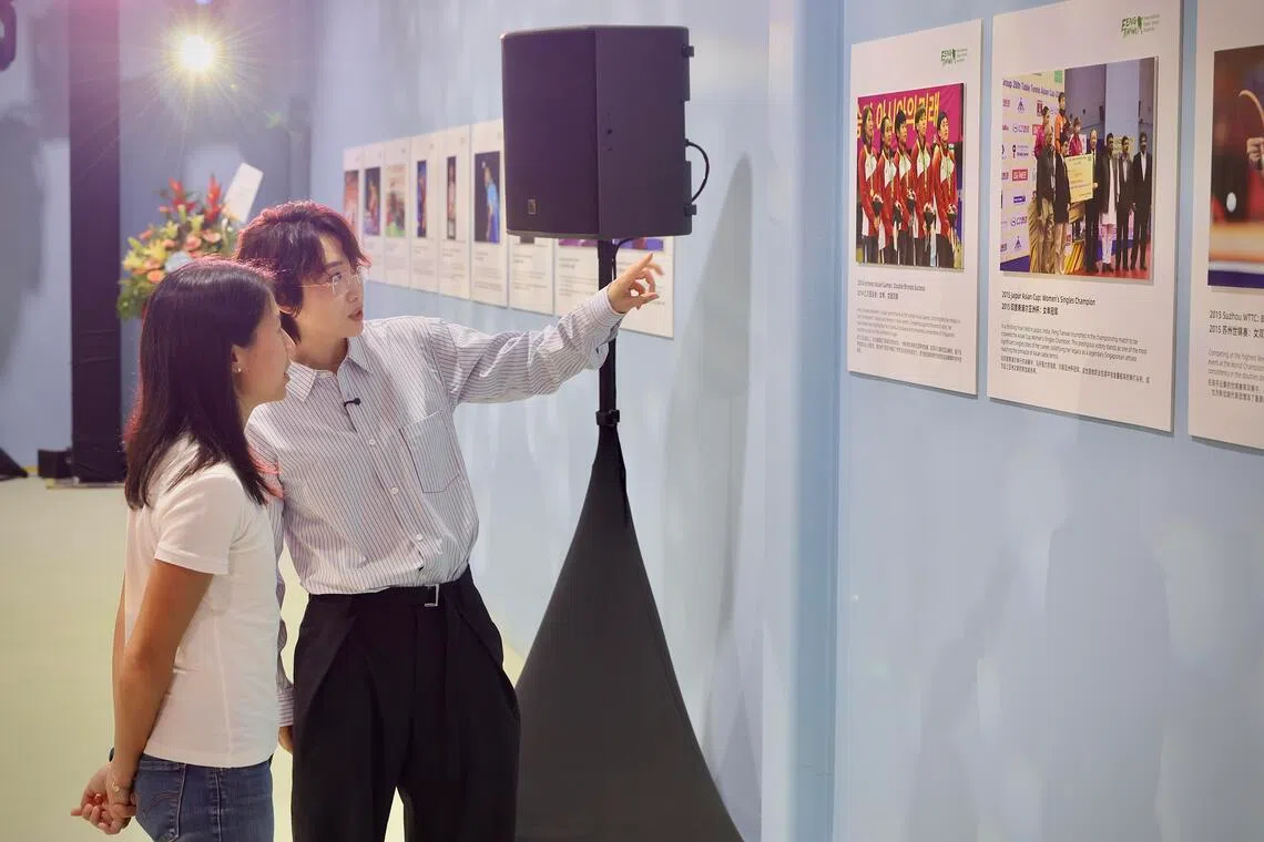 冯天薇（右）向永续发展与环境部兼文化、社区及青年部高级政务次长吴函燕展示球馆内的照片墙。（龙国雄摄）