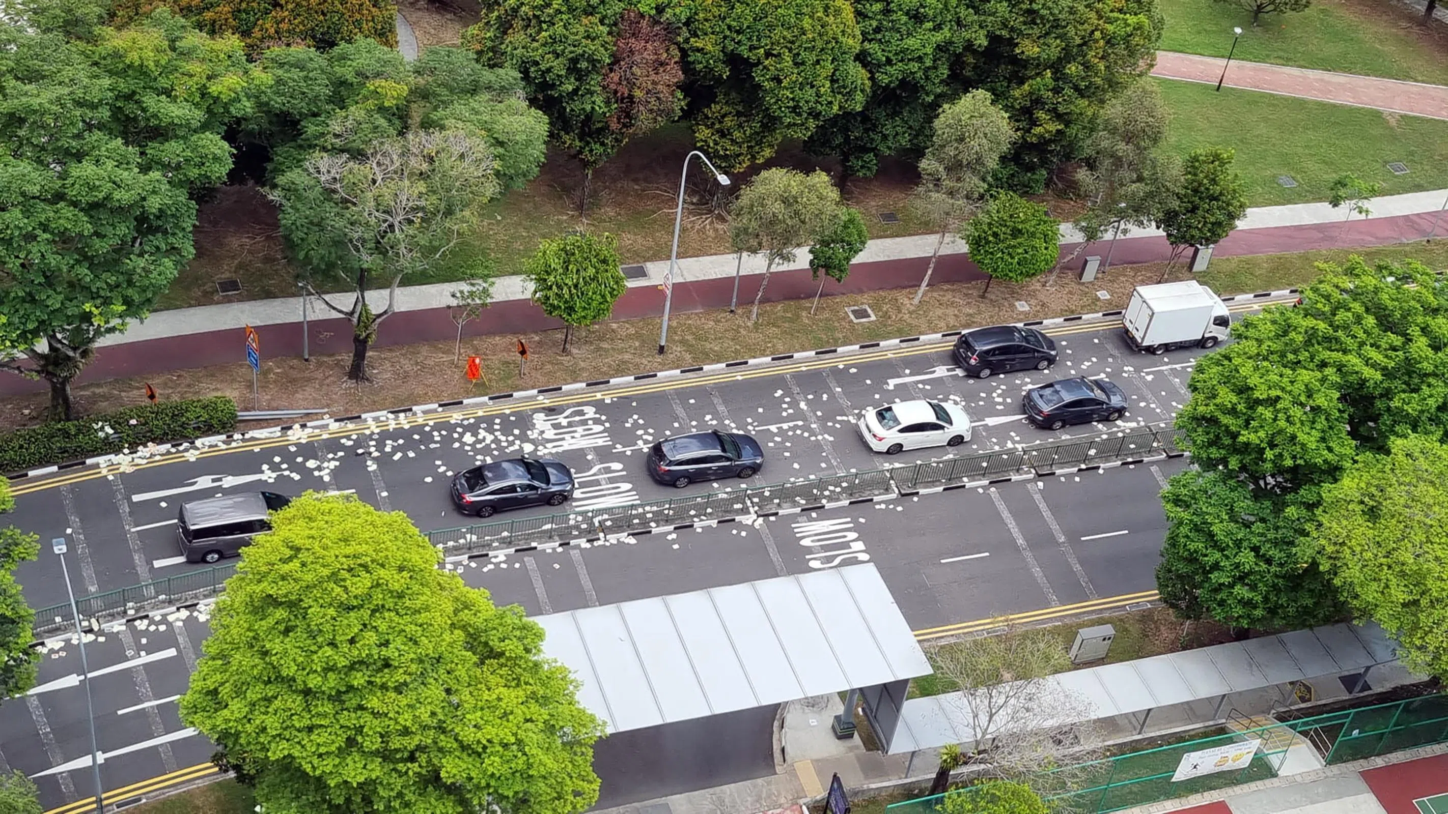 大量冥纸随风飘散在沿路上。（受访者提供）