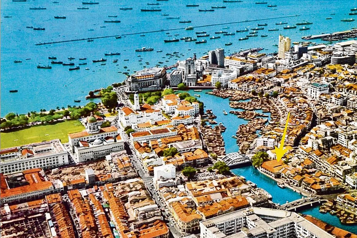 新加坡河畔的丰兴货仓（箭头指处）。（明信片）