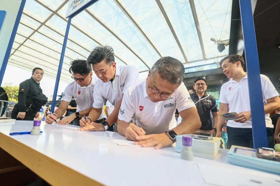 律政部长兼内政部第二部长唐振辉（右二），在“爸爸外出日”上参加了寄明信片给父亲的活动。（陈渊庄摄）