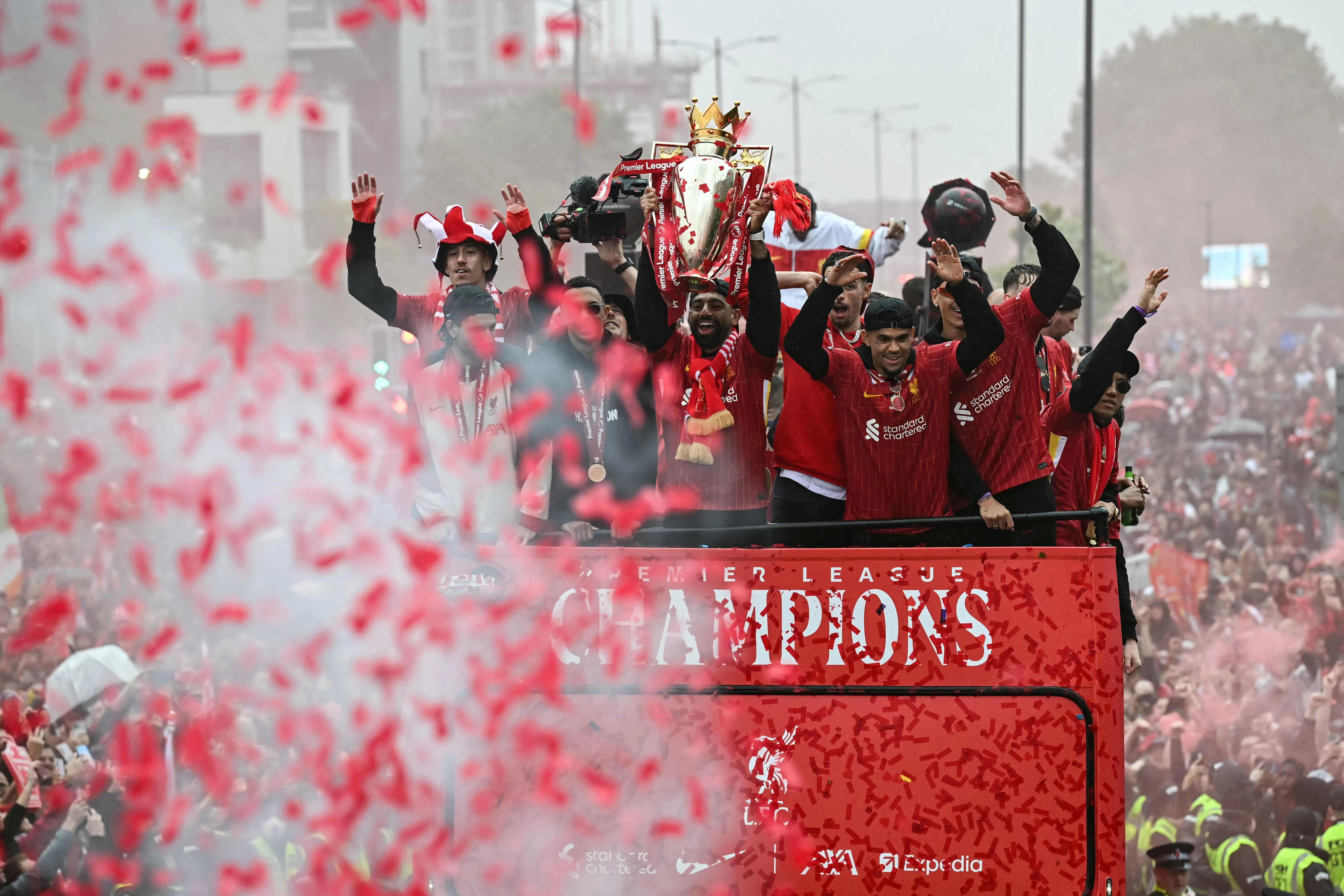 利物浦球星萨拉赫在冠军游行中捧起英超奖杯，但现场不久后发生了汽车撞人的不幸事故。（法新社）