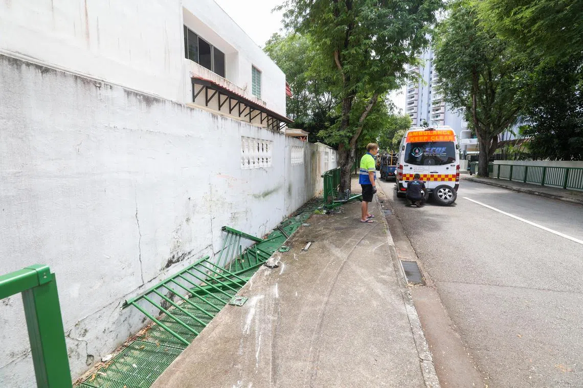 民防部队救护车与汽车相撞，路旁一整排栏杆都被撞断。（吴先邦摄）