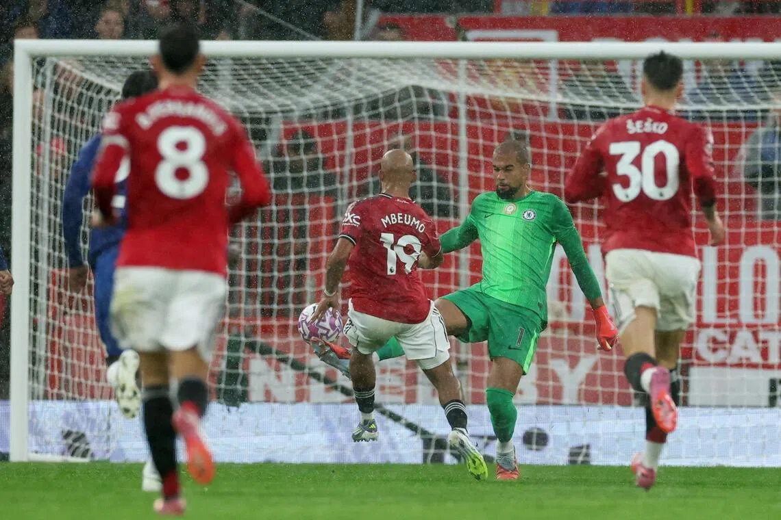 为了防守红魔新援姆伯莫（19号）的单刀球，蓝军门将桑切斯（绿衣）冲至禁区外，但不慎放倒对手，在开场第五分钟就染红离场。（路透社）