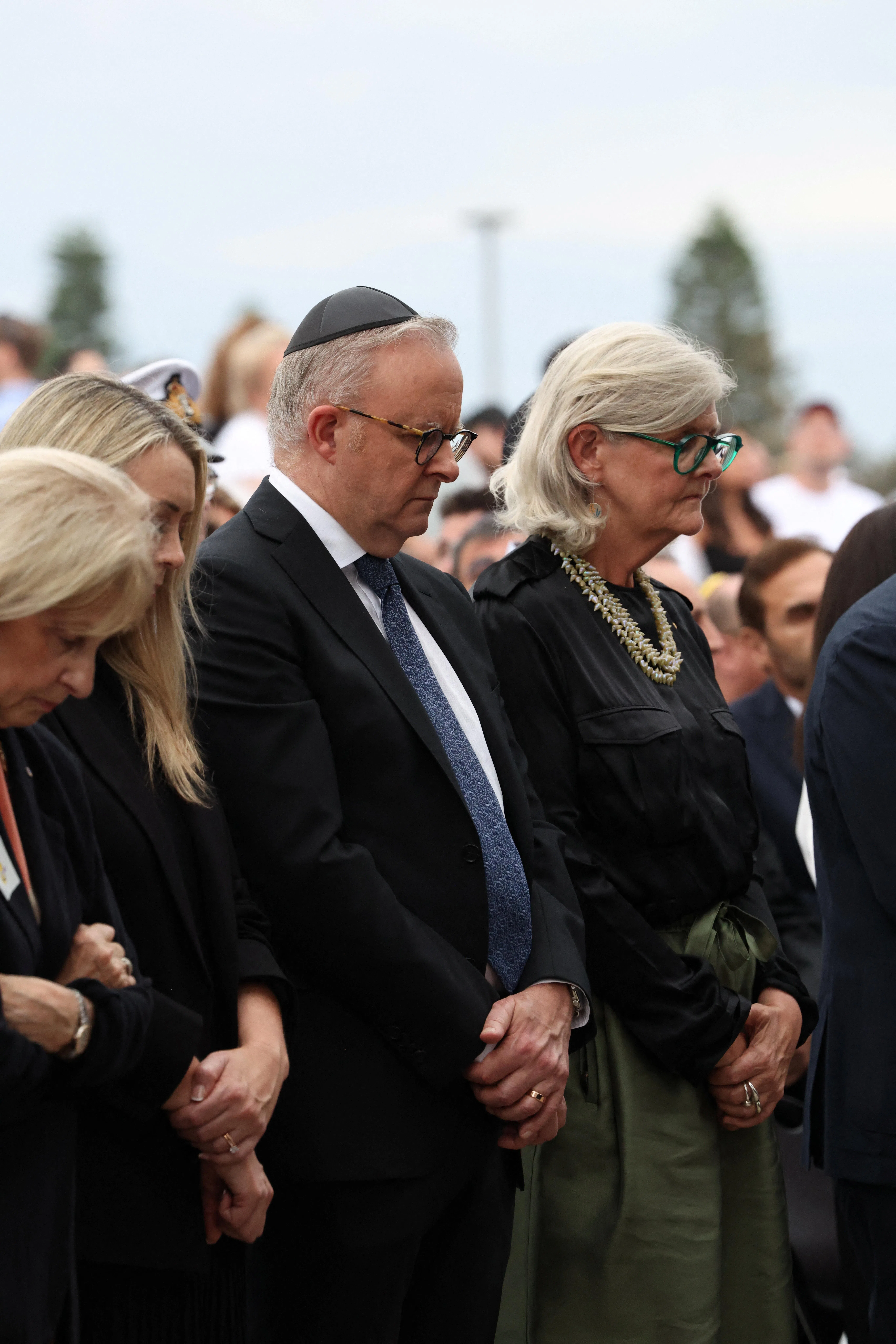 澳洲总理阿尔巴尼斯（中）在邦迪海滩，与民众一同为一周前枪击案的死者默哀一分钟，他戴上传统的犹太小圆帽，但没有在悼念活动上发言。（路透社）