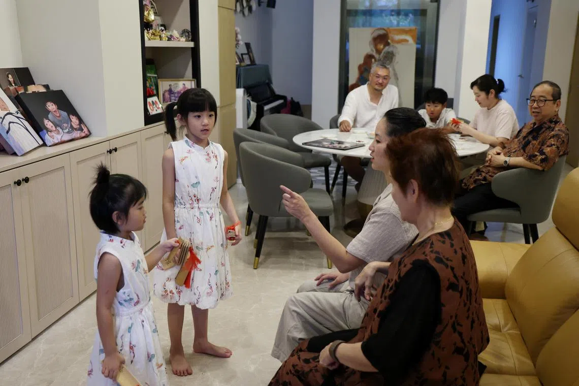 两个小孙女在外婆严众莲（右一）和妈妈蔡适吉的引导下耍快板。严众莲和蔡兆祺（后排右一）夫妇对艺术教育的坚持延续到下下一代。（梁麒麟摄）