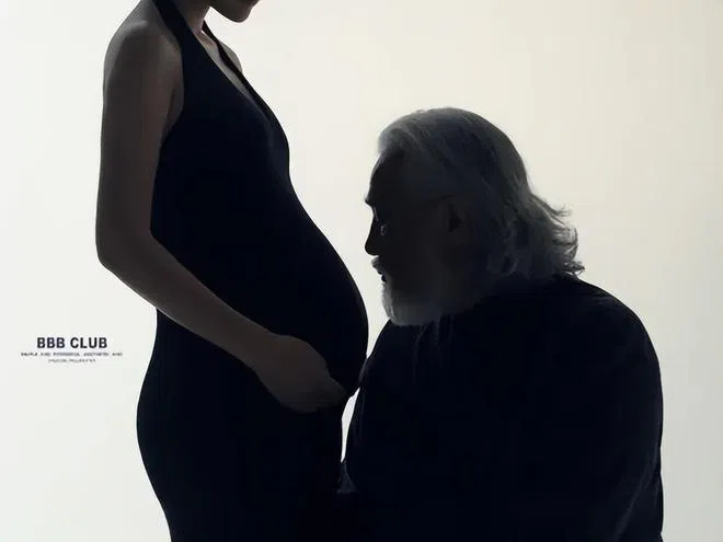 张纪中（右）学年轻人的方式玩浪漫，半蹲侧身亲吻老婆孕肚。（取自张纪中微博）