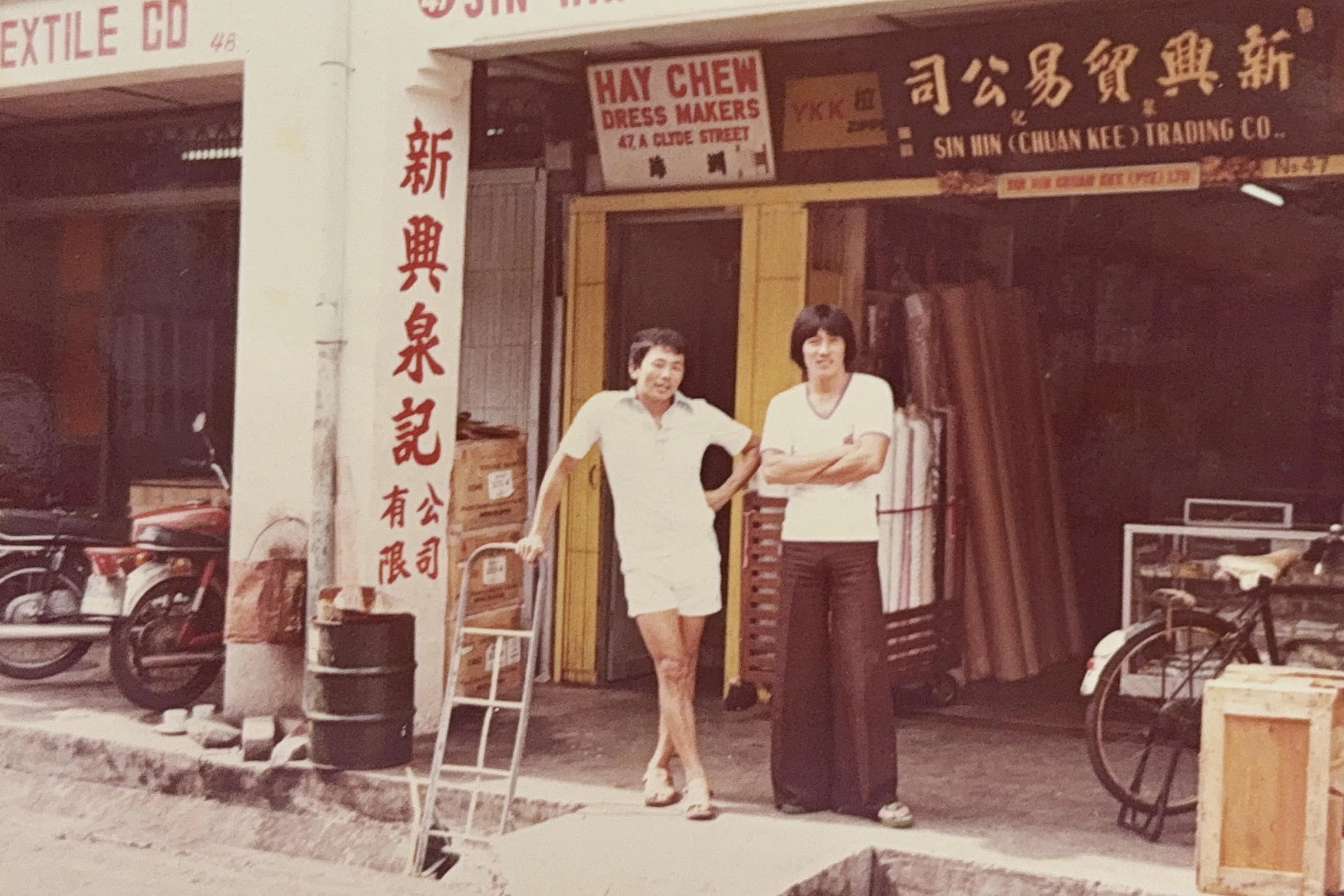 第二代接班人之一黄昭宝（左）与友人，站在克莱街的原店铺外。（受访者提供）