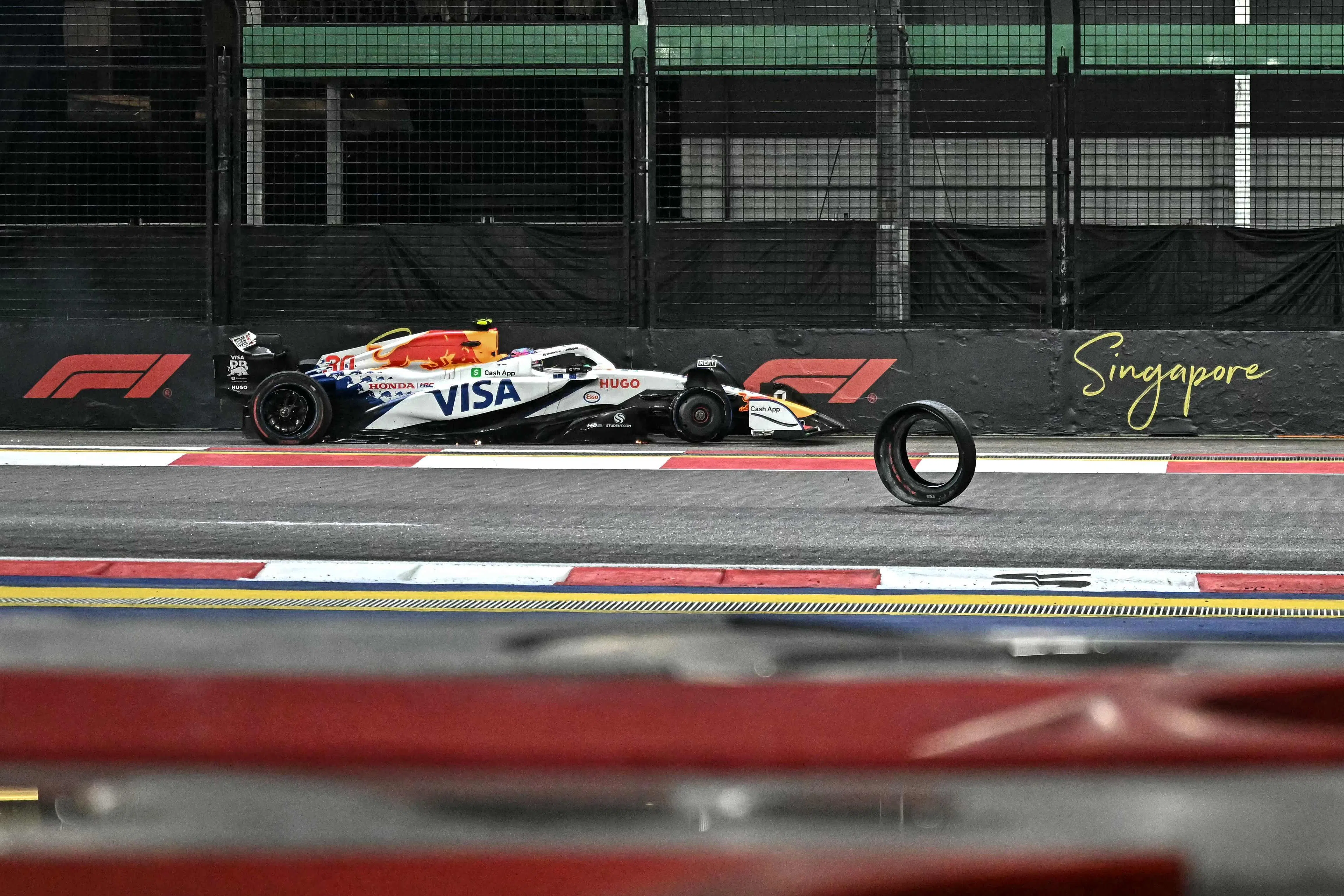 劳森的赛车在维修站前蹭墙，右前轮外层脱落掉在路中央。（法新社）