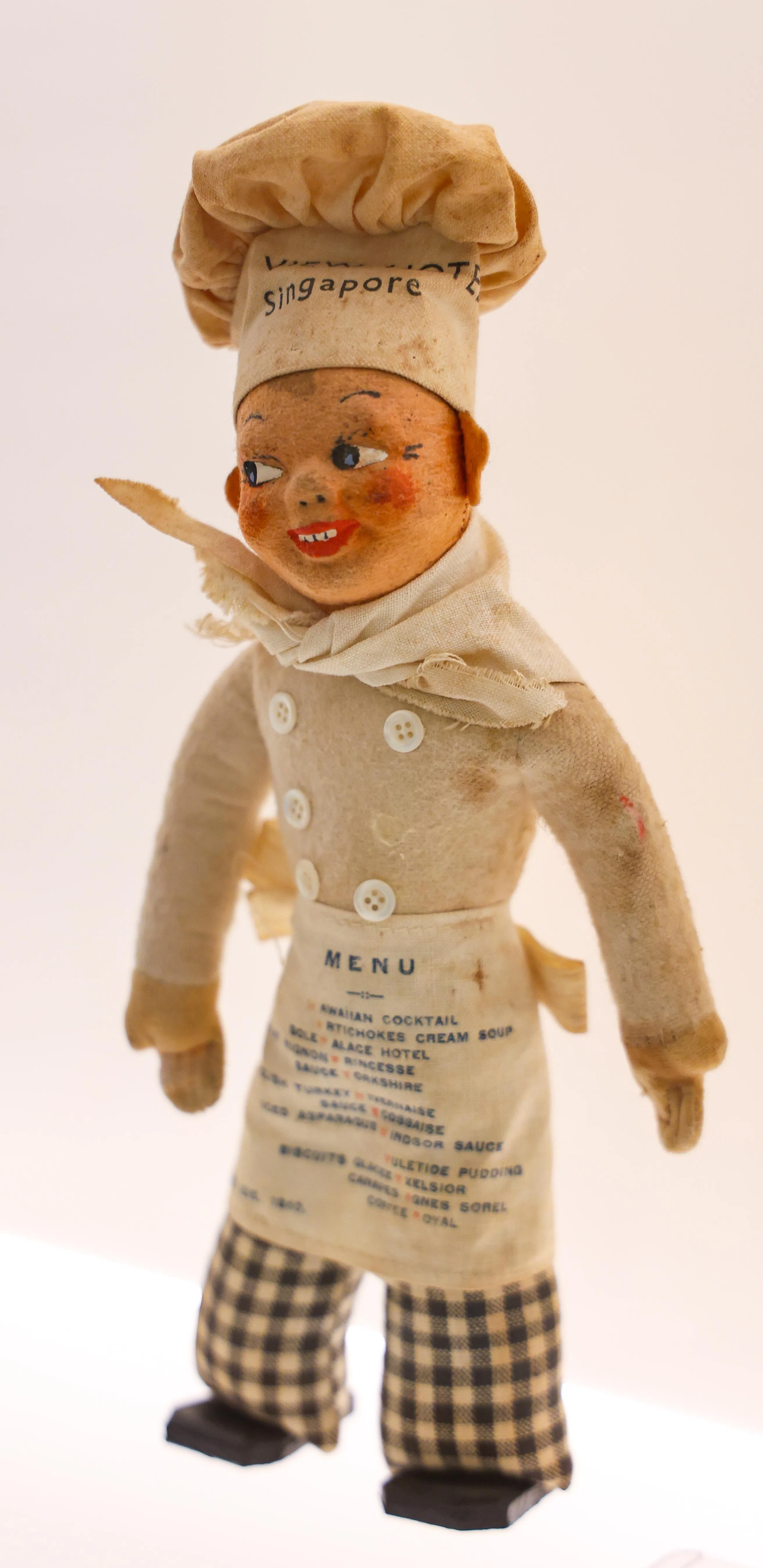 这位“海景酒店厨师”玩偶静静见证了新加坡在二战中沦陷前的繁华一夜。（林明顺摄）