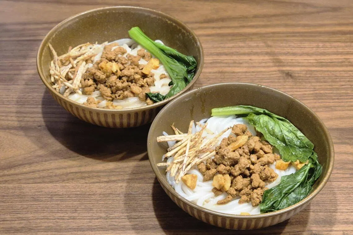 肉碎老鼠粉（前）和客家干捞面有猪肉碎、油渣和炸芋丝，味道丰富，口感多样。（陈爱薇摄）