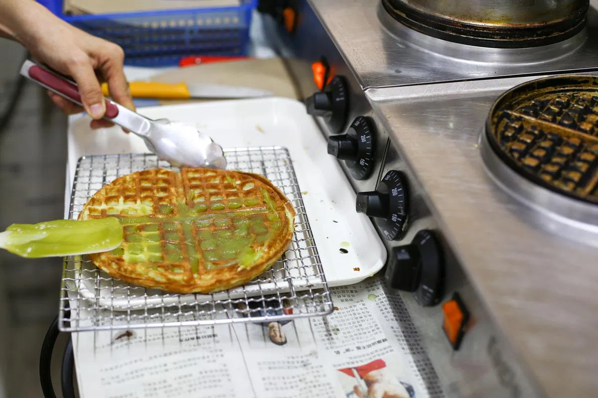 现做现卖的班兰华夫饼，价廉物美，浓郁的香味常让人忍不住驻足。（白艳琳摄）