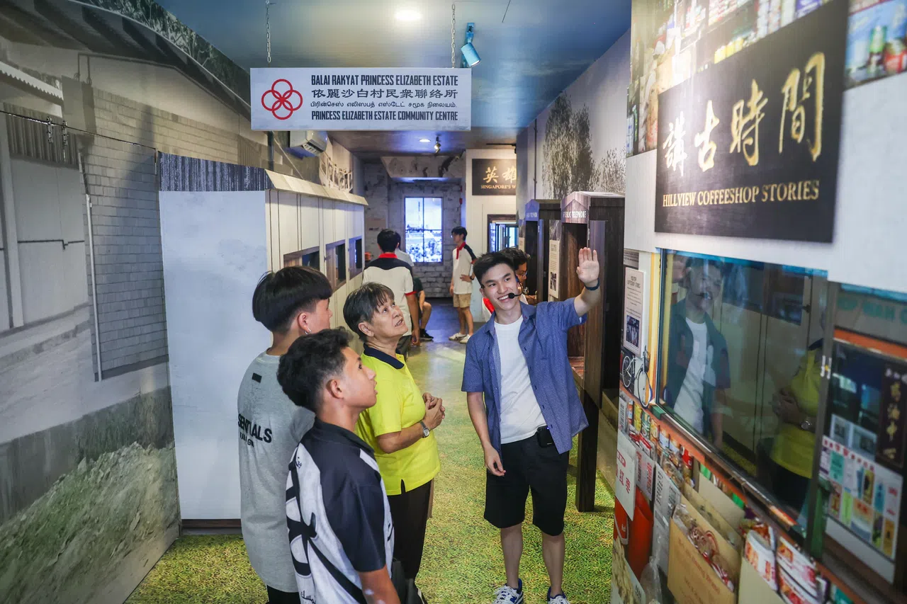 山景民众俱乐部5月5日举办开幕五周年庆典，吸引约1000名公众参与。图为青年志愿者蔡劲恩（19岁，右）为民众讲解新设立的历史长廊中的展出。（白艳林摄）