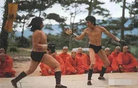 洪金宝（左）在《精武门》中和李小龙（右）对打，当时他还拉上成龙当替身。（互联网）