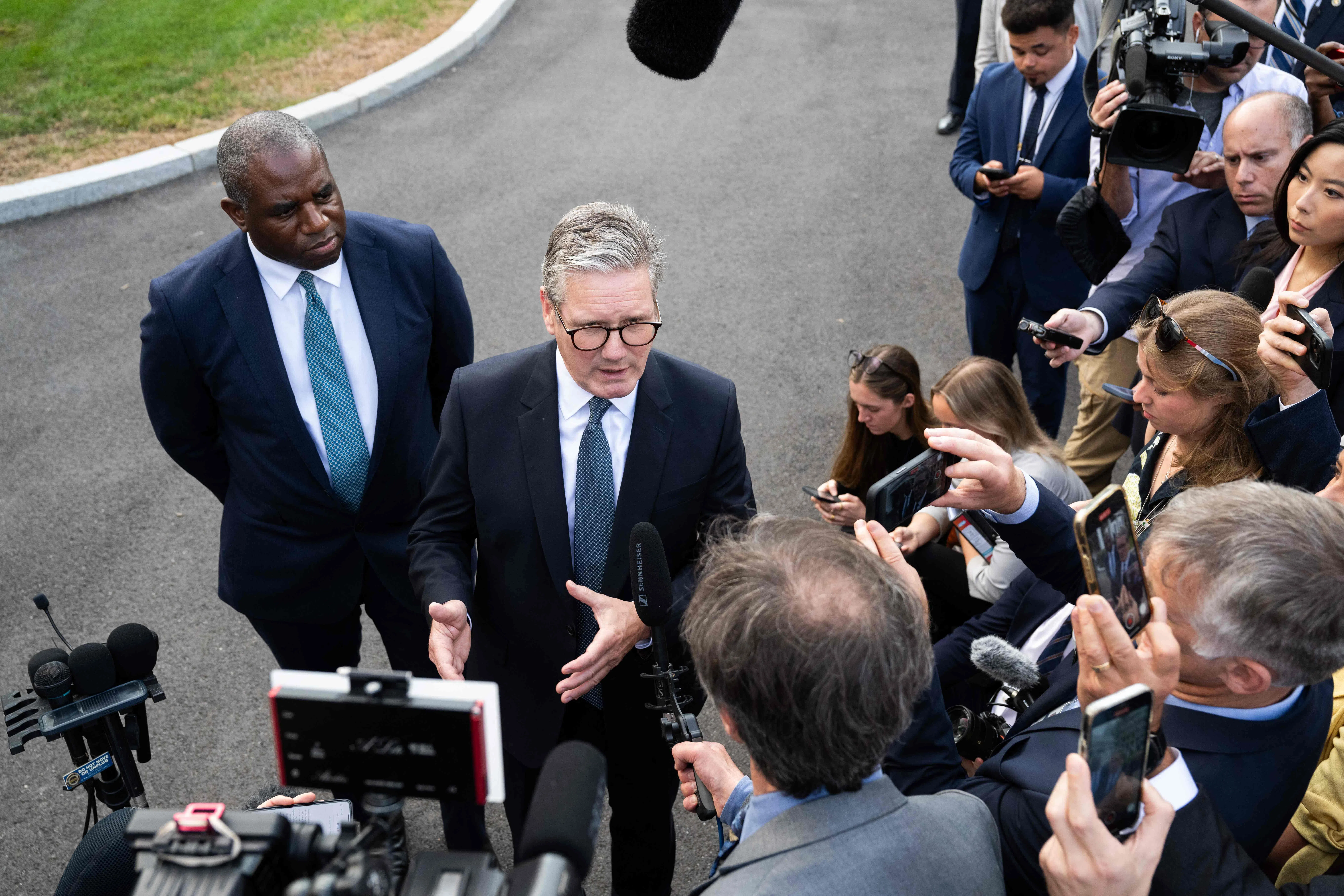 英国首相斯塔默（中）与美国总统拜登举行会议后向媒体发表讲话。英国外长拉米（左）也出席了会议。（法新社）