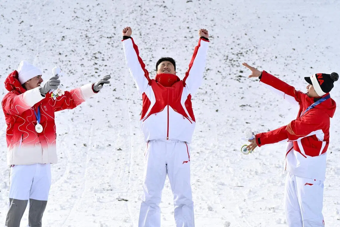 银牌得主罗斯（左）和铜牌得主李天马（右）张开双臂，恭喜王心迪摘下金牌。（法新社）