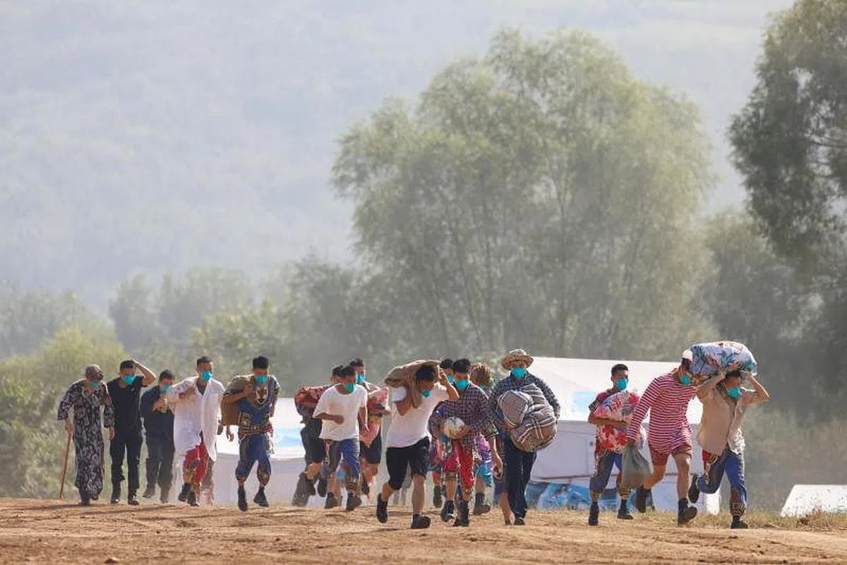 由士兵饰演的难民在炸弹的烟尘中逃避。（路透社）