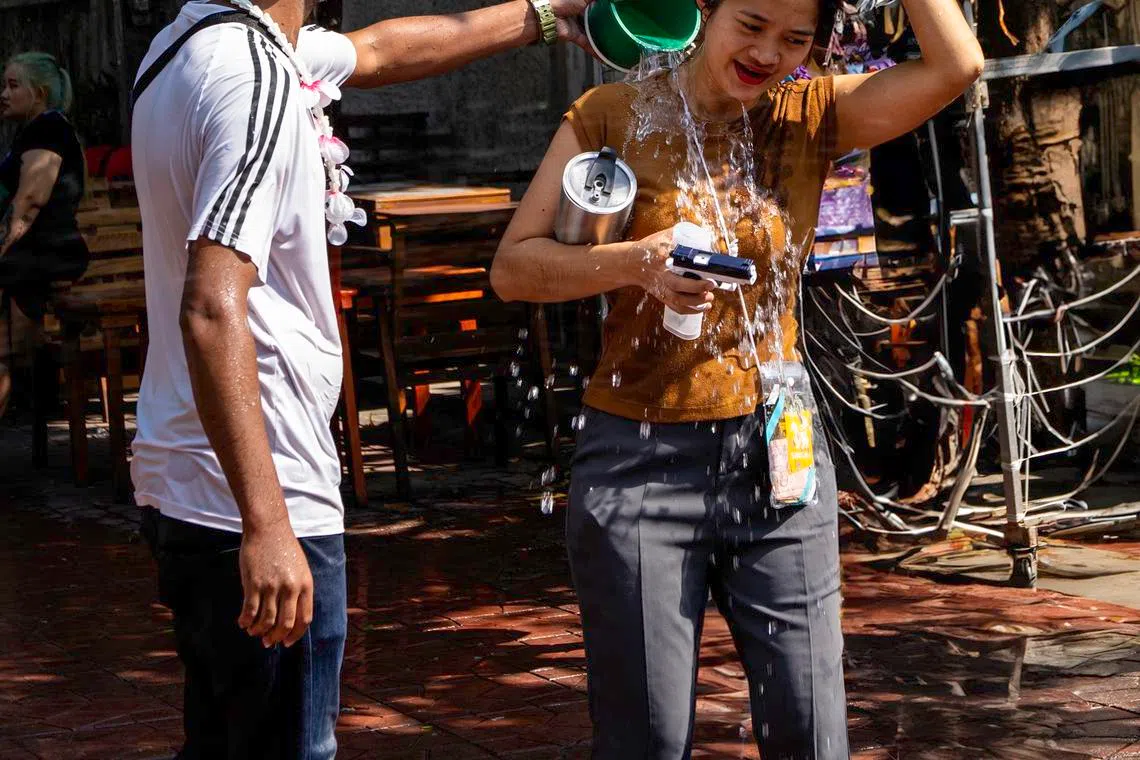 小水桶倒出祝福，也为酷热天气降温。（蔡光发摄）