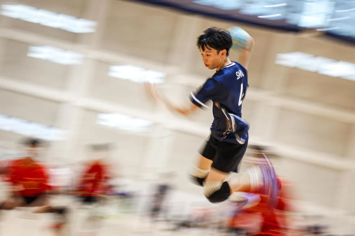 新加坡管理大学队4号左翼球员，跃起高抛传球，将球送往右翼。（游甯稀摄）