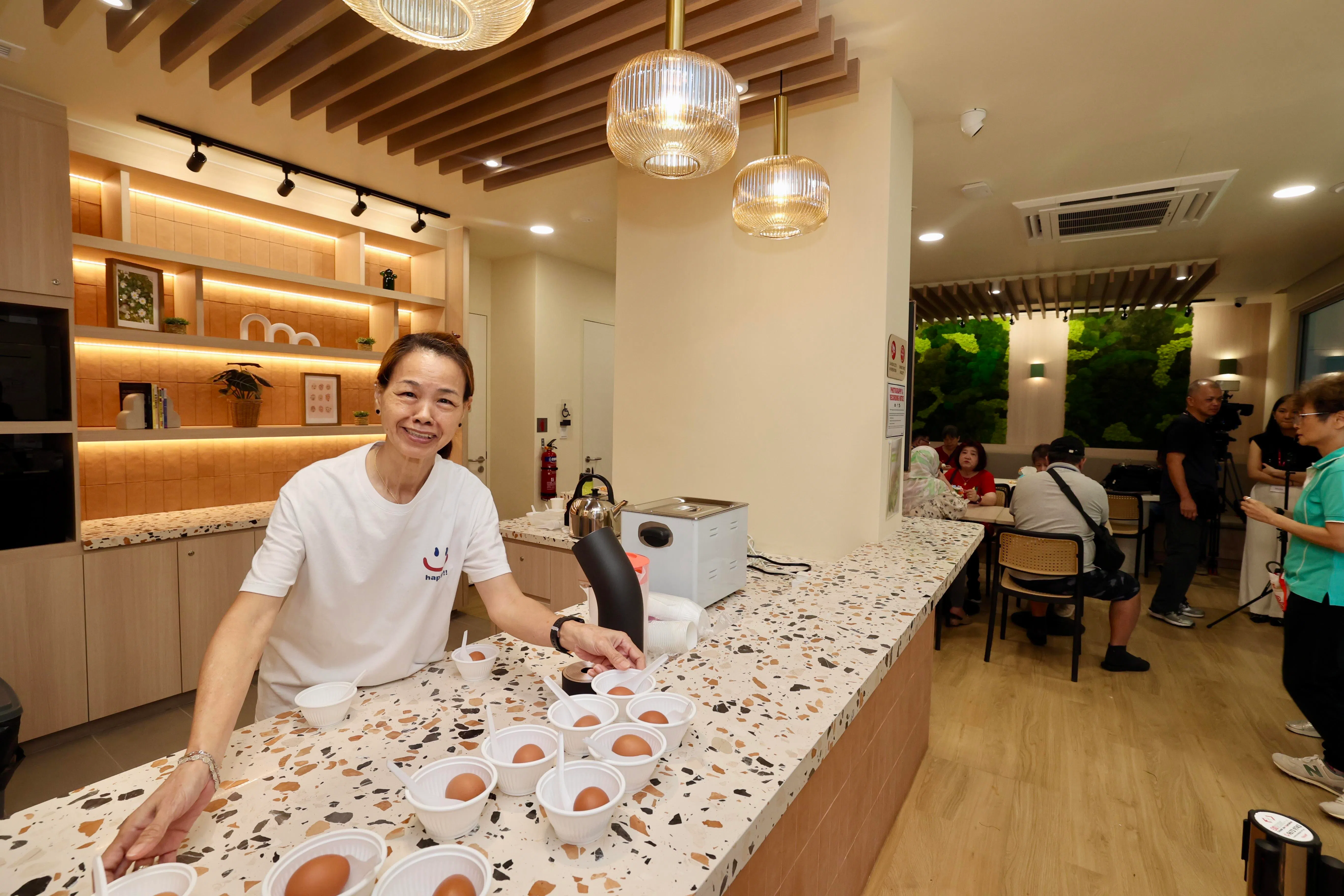 林碧凤每周两天会到咖啡座帮忙，准备鸡蛋和咖啡，招待前来的乐龄朋友和居民。（邝启聪摄）