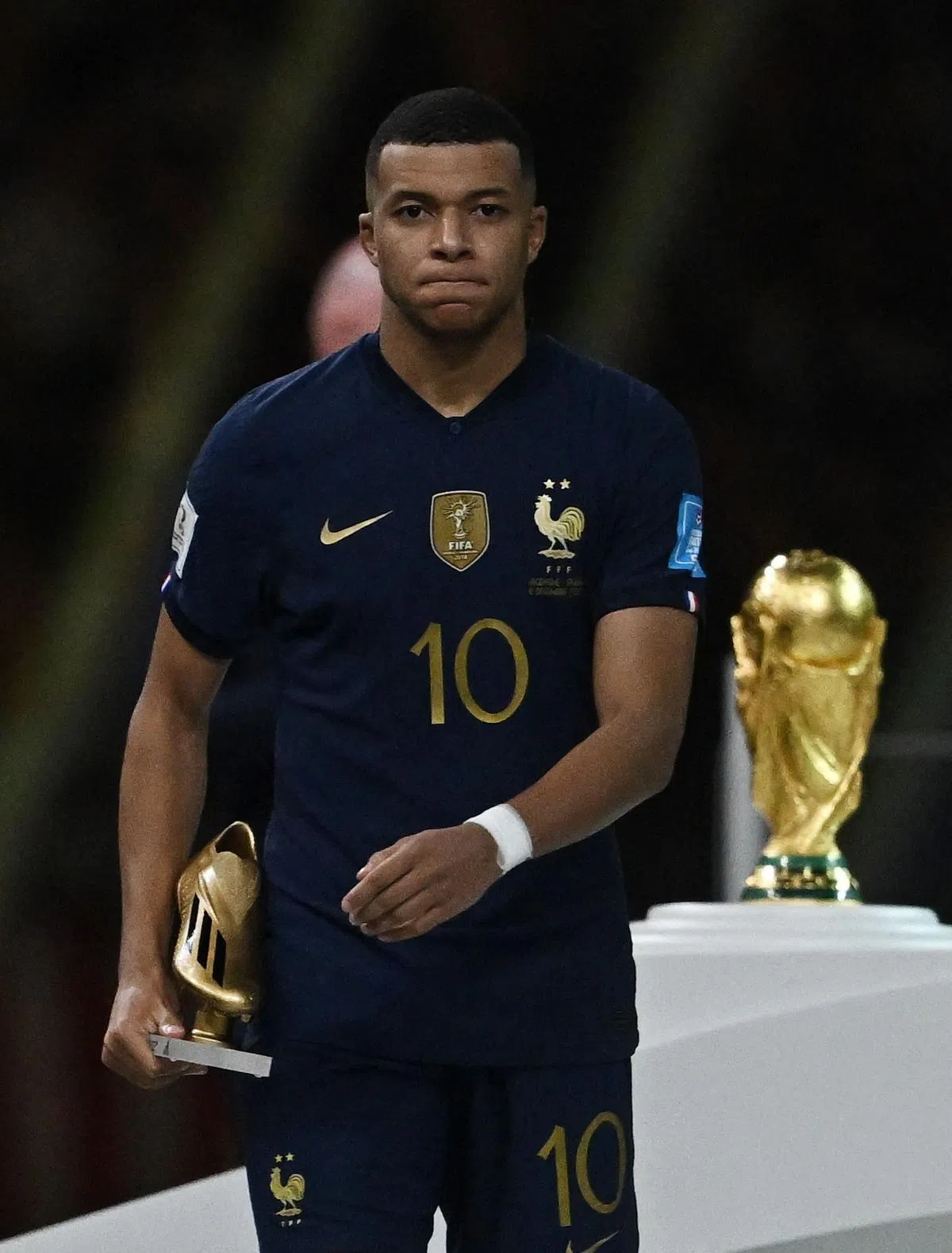 成为世界杯史上第二位在决赛完成帽子戏法的球员，法国球员姆巴佩却只能捧着金靴，眼中满是不甘。（路透社）