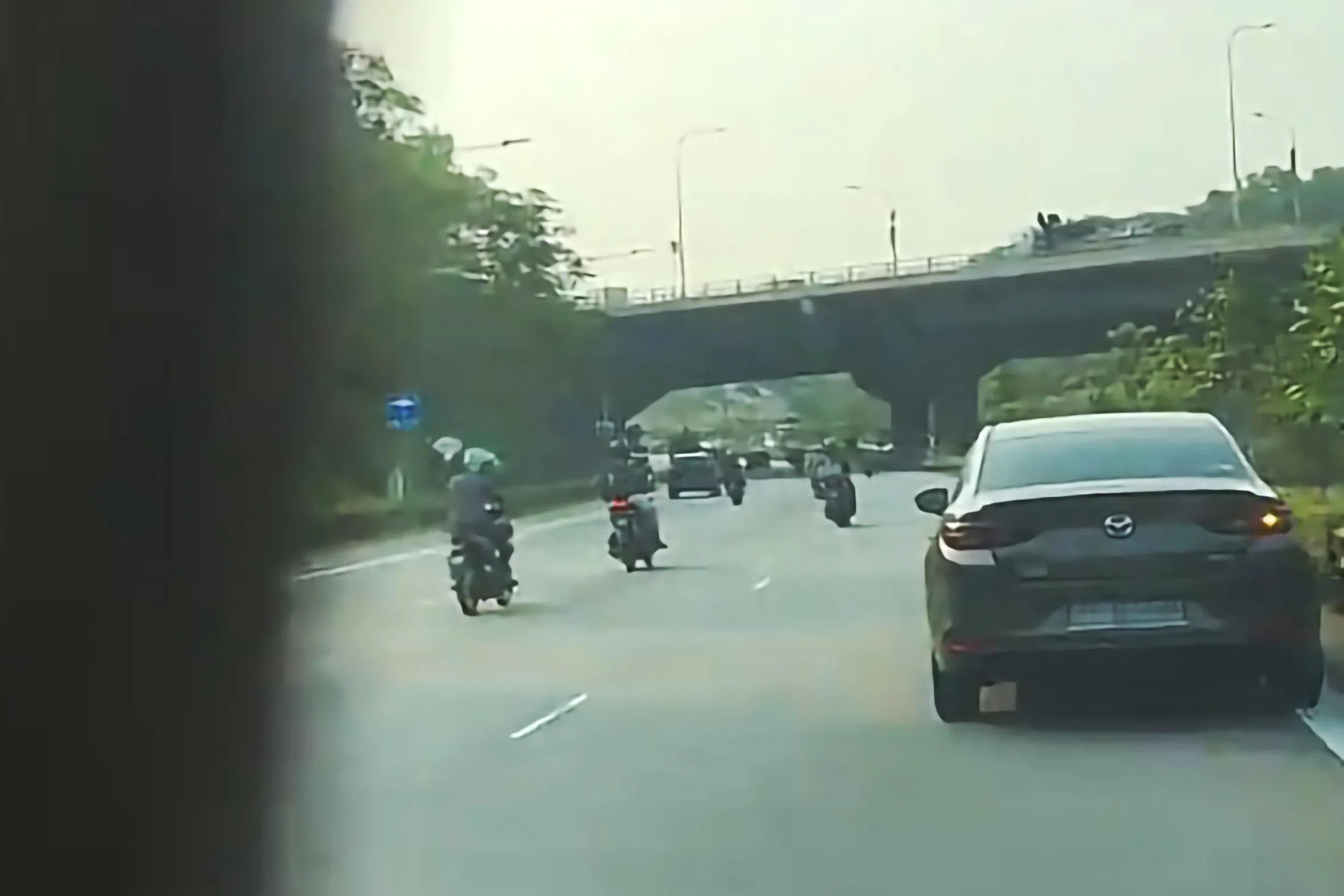 黑色马自达汽车在路上危险蛇行，险些撞上数名电单车骑士。（取自JustPlayProduction TikTok）