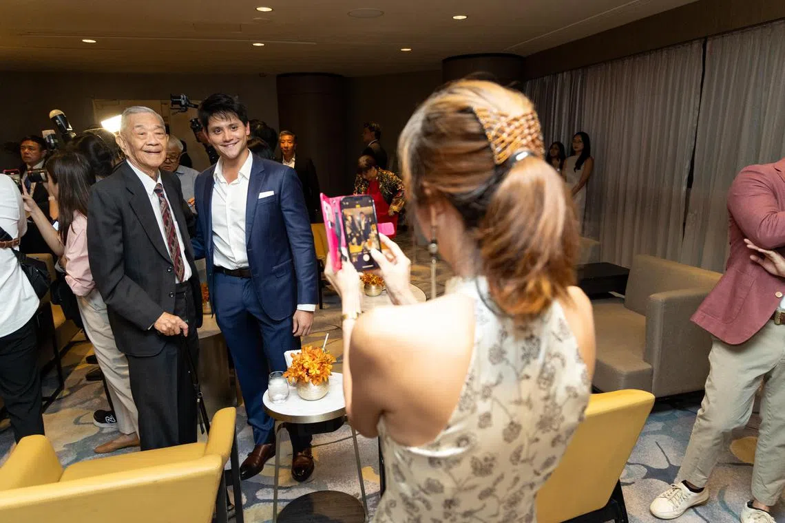 我国奥运冠军约瑟林（后右）在晚宴上和92岁的前泳手徐文熙合影。（关俊威摄）