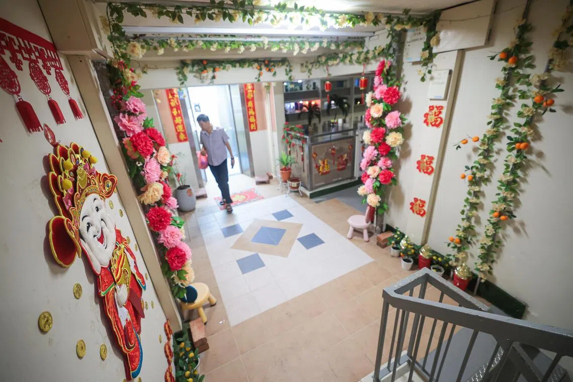 财神到！财神到我家大门口！勿洛水池路第131座组屋有居民在电梯口布置财神爷和花卉装饰，营造温馨的节庆气息。（李冠卫摄）