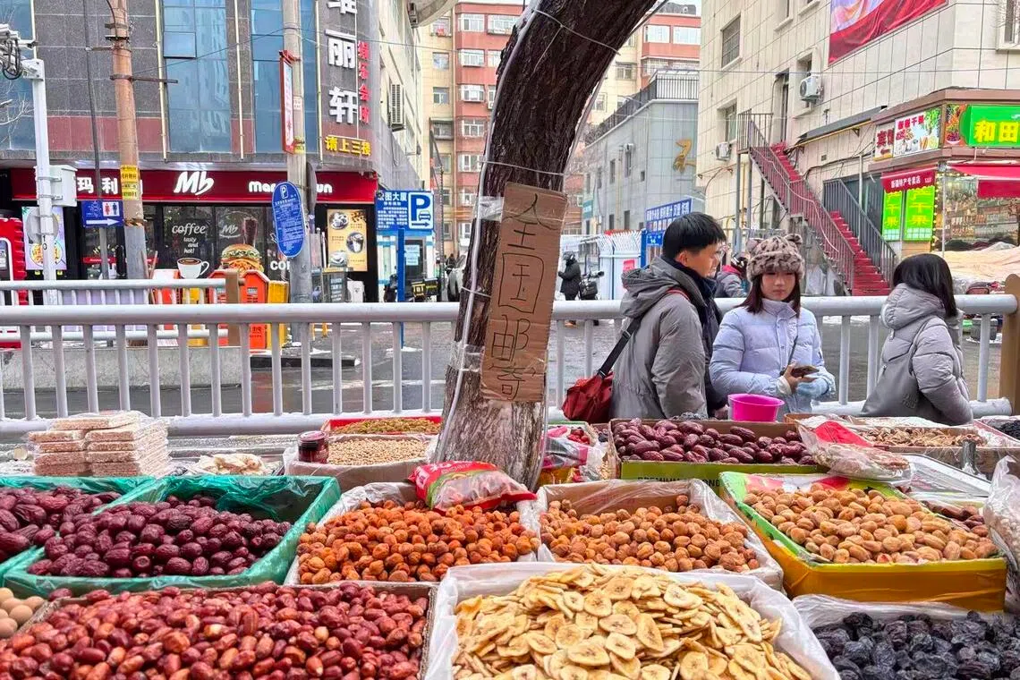 乌鲁木齐和田二街上一家干货店外，几名今年1月到访的内地游客在选购新疆特产。（黎康摄）