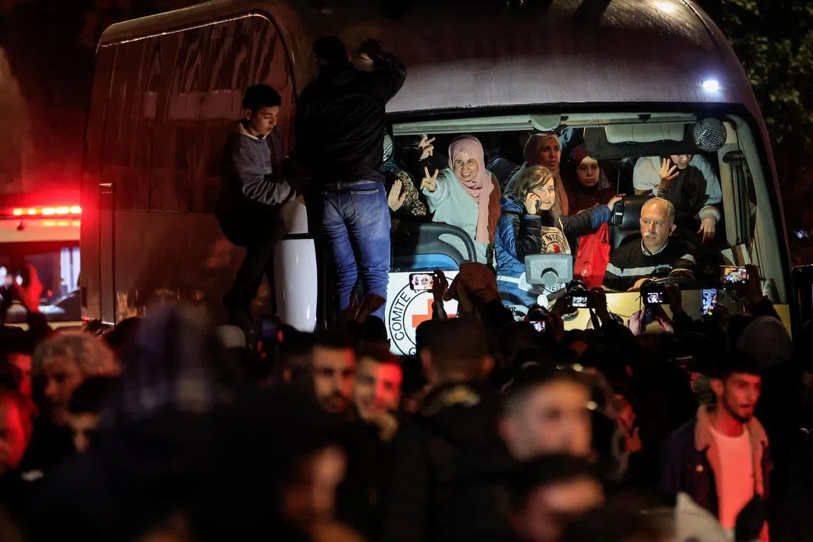 1月20日，获释巴勒斯坦囚犯在大巴车中比出V手势。（路透社）