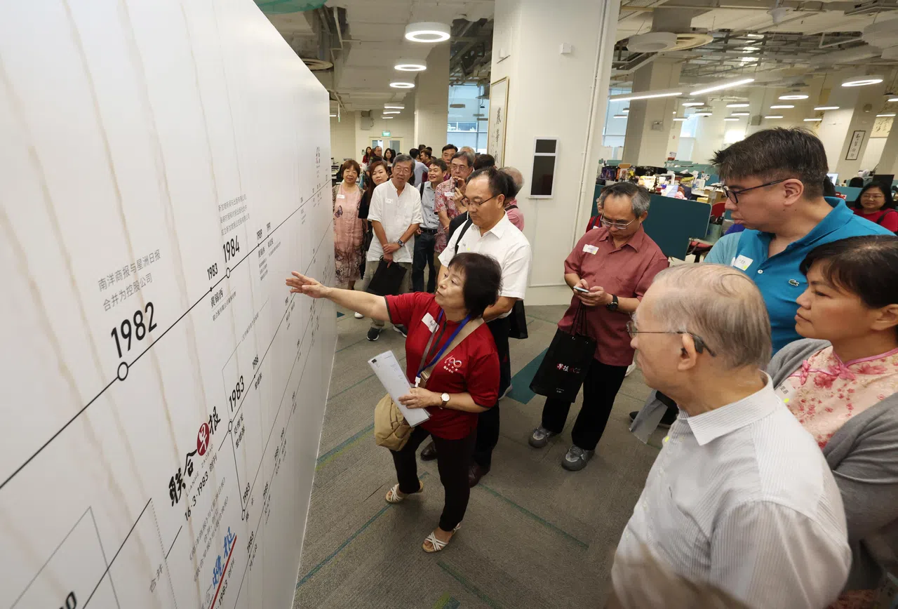 交流会结束后，不少专栏作者到早报新闻室参观，了解2023年4月设立的华文报历任总编辑纪念墙。（陈渊庄摄）