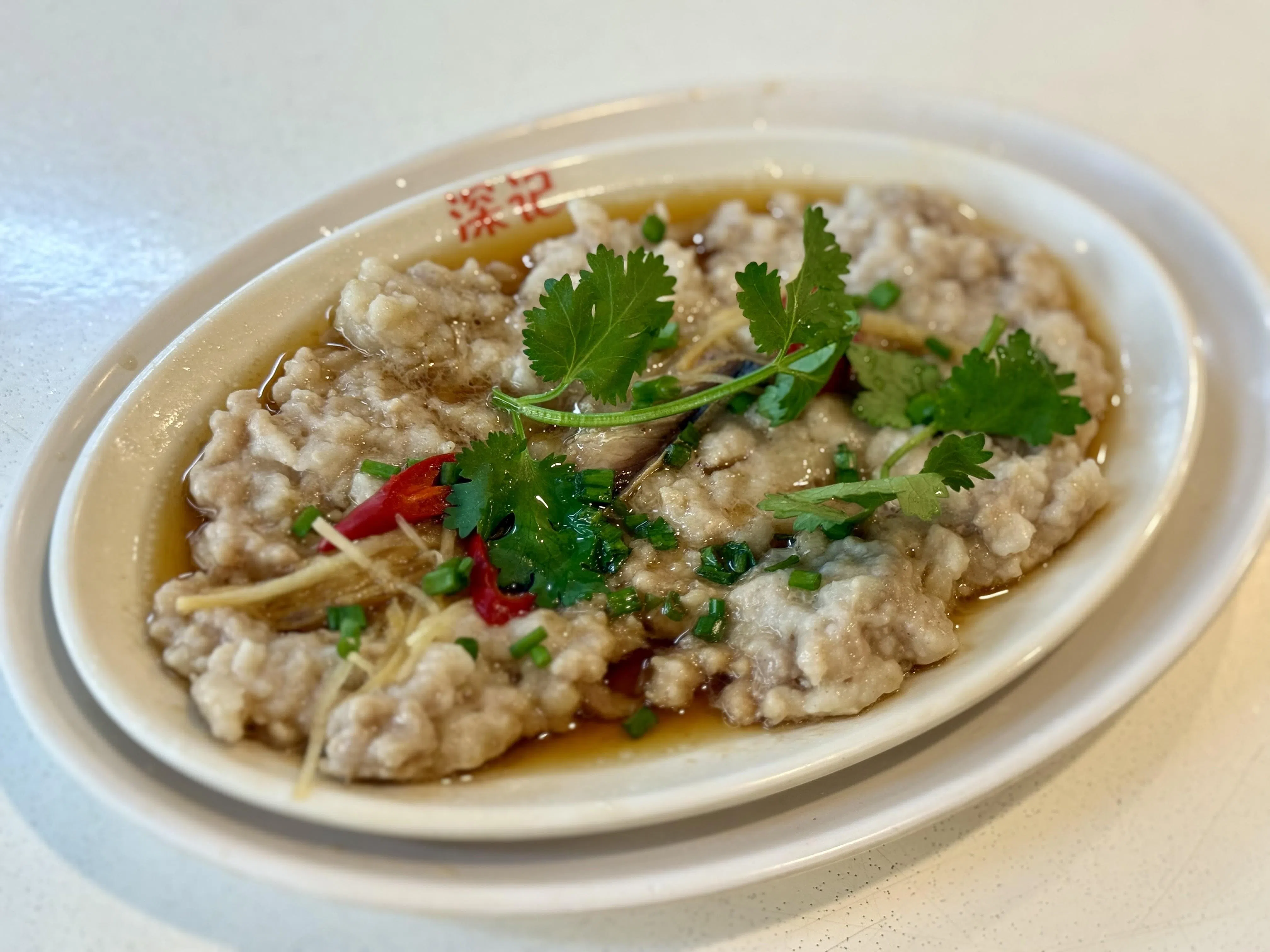 咸鱼肉饼选用肥瘦相间的猪肉，蒸至软嫩多汁，搭配咸香浓郁的咸鱼碎，十分下饭。（叶晓虹摄）