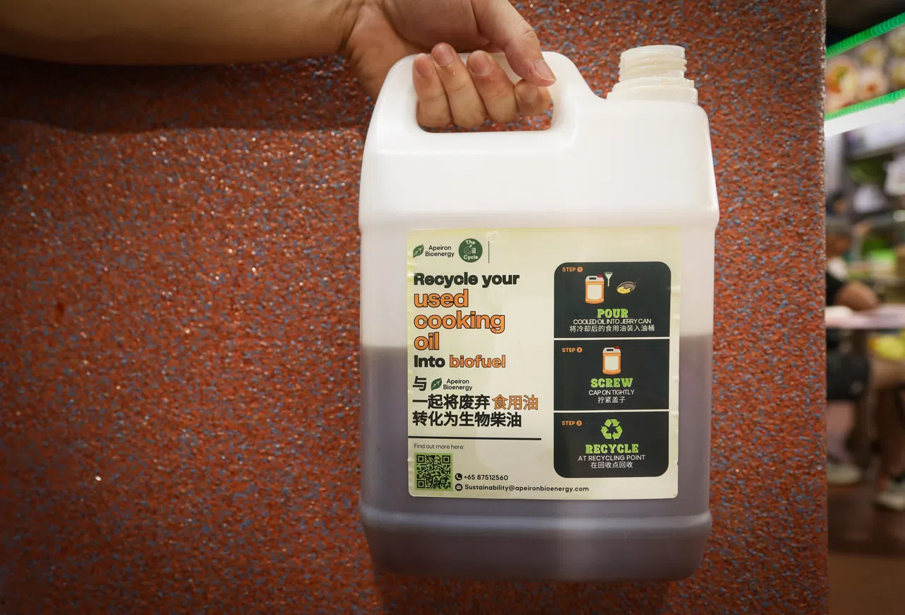 塑料桶标注了回收步骤，教导小贩把用过的食用油装入桶里、拧紧桶盖，拿到回收点回收。（张恺恩摄）