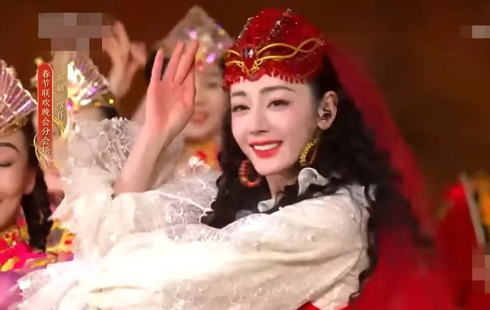 迪丽热巴身穿家乡民俗服装，配着一束黝黑长卷发，非常亮丽。（互联网）