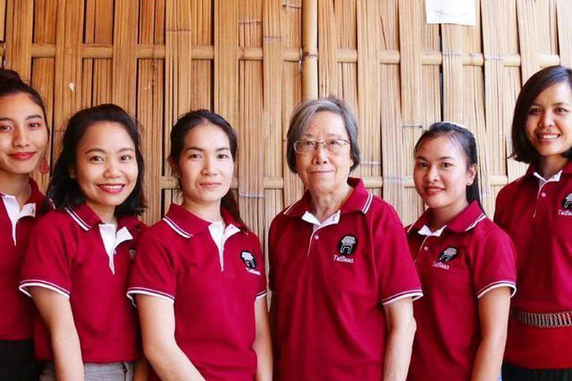 旅居老挝超过30年的吴瑞明（右三）在万象经营社会企业TaiBaan。图为她和员工合照。 （受访者提供）