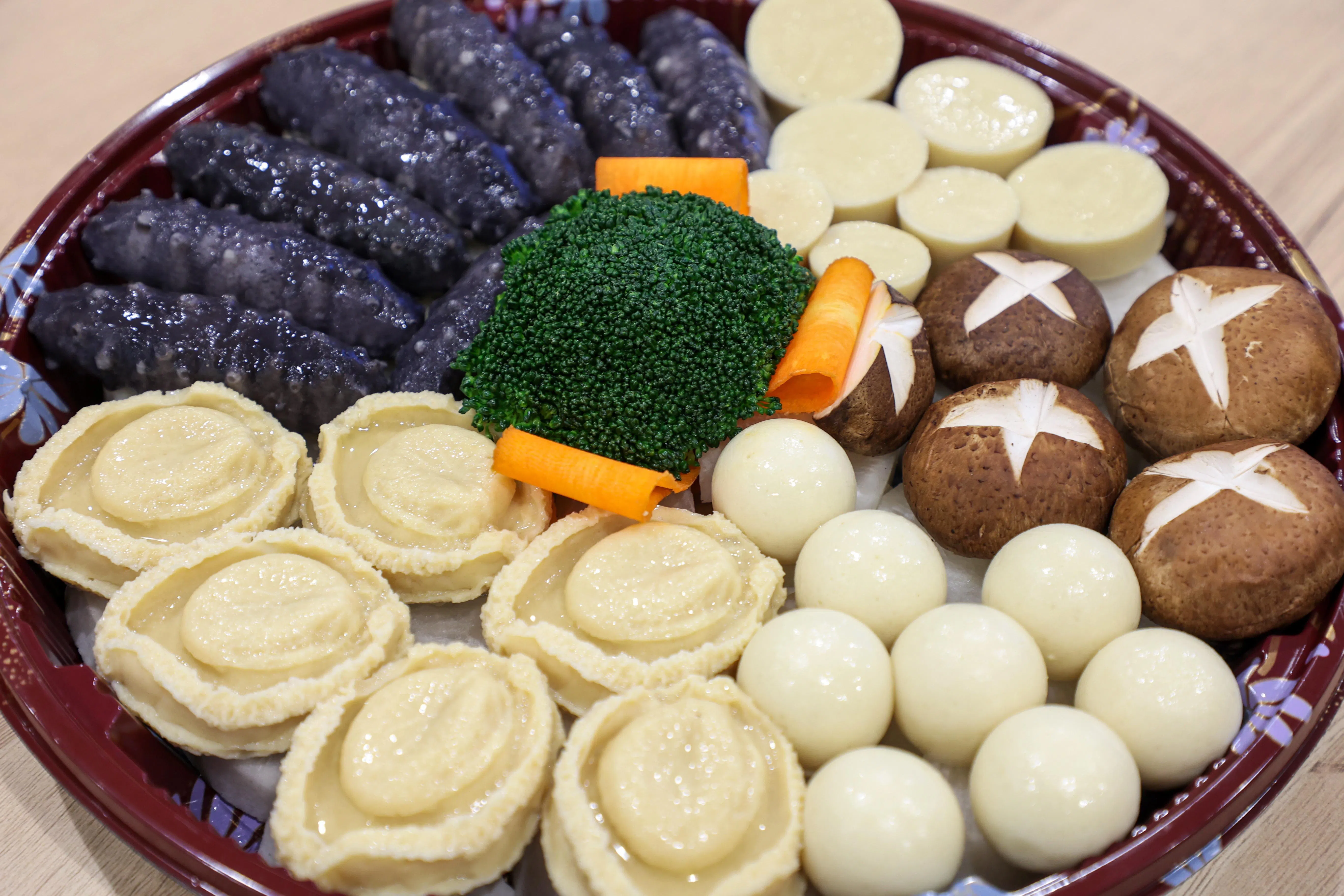盆菜，顾名思义，是在盆里层层叠叠放10多种食材，包括鲍鱼、海参等海鲜，以及各种蔬菜。采用植物鲍鱼和植物海参做的盆菜更健康环保。（游甯稀摄）