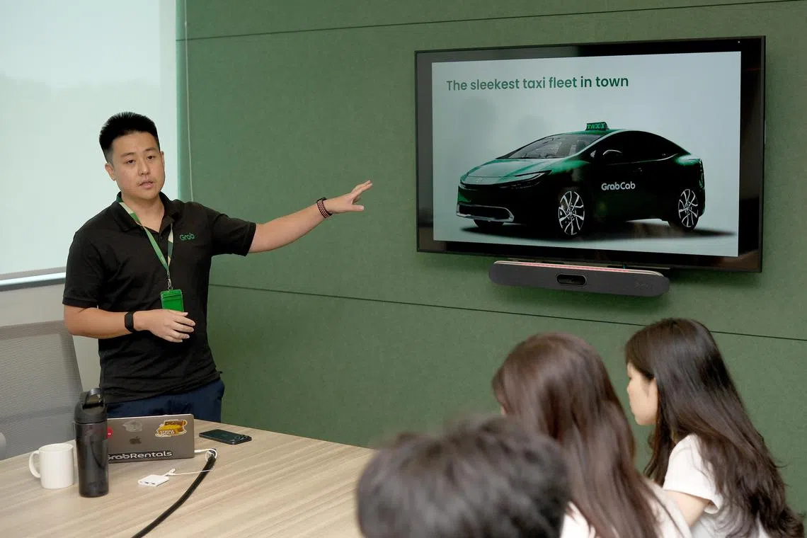 GrabRentals与GrabCab新加坡总监沈威得（左）日前在Grab总部，向媒体介绍GrabCab的节能车队。（曾坤顺摄）