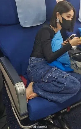 李一桐搭飞机时脱掉鞋子，把光脚丫子直接放在椅垫上。（取自微博）