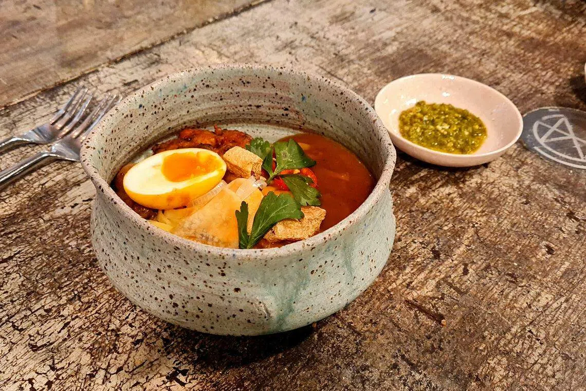 有别于一般马来卤面，搭配以香菜和腌青辣椒制成的辣酱，十分讨好味蕾。（叶晓虹摄）