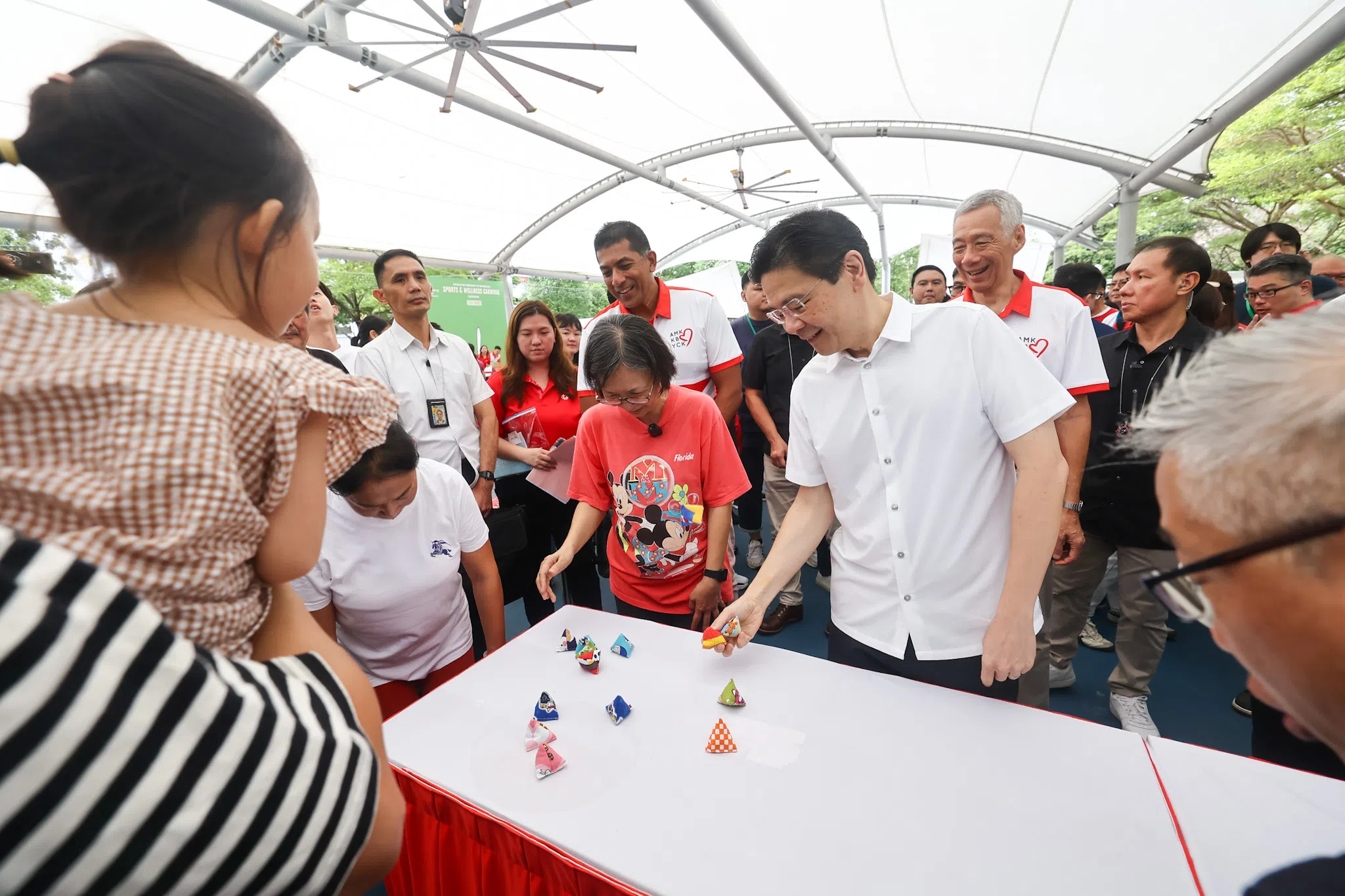 黄循财总理（第一排，白衣）星期六出席体育保健嘉年华并尝试玩游戏，国务资政李显龙（总理后方右二）与宏茂桥集选区议员杰乐（总理后方右三）也在场参与。（陈渊庄摄）