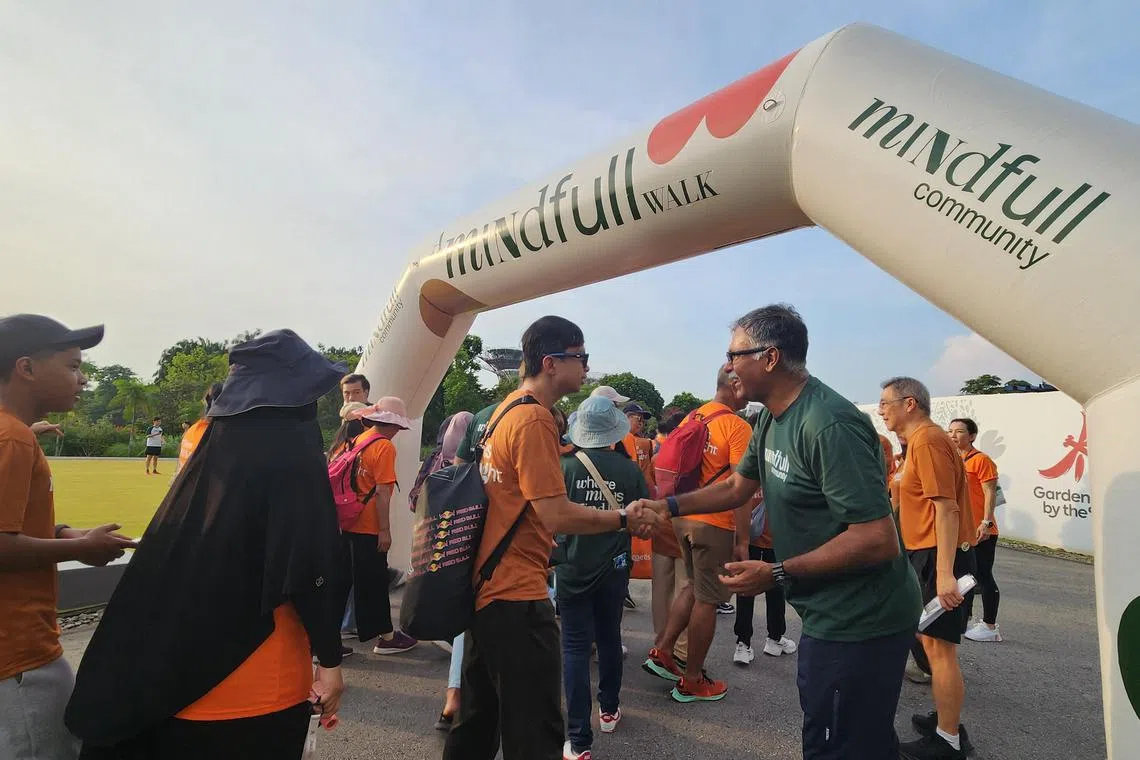 律政部兼交通部高级政务部长穆仁理（右一）在义走活动现场与看护者握手互动。（赵世楚摄）