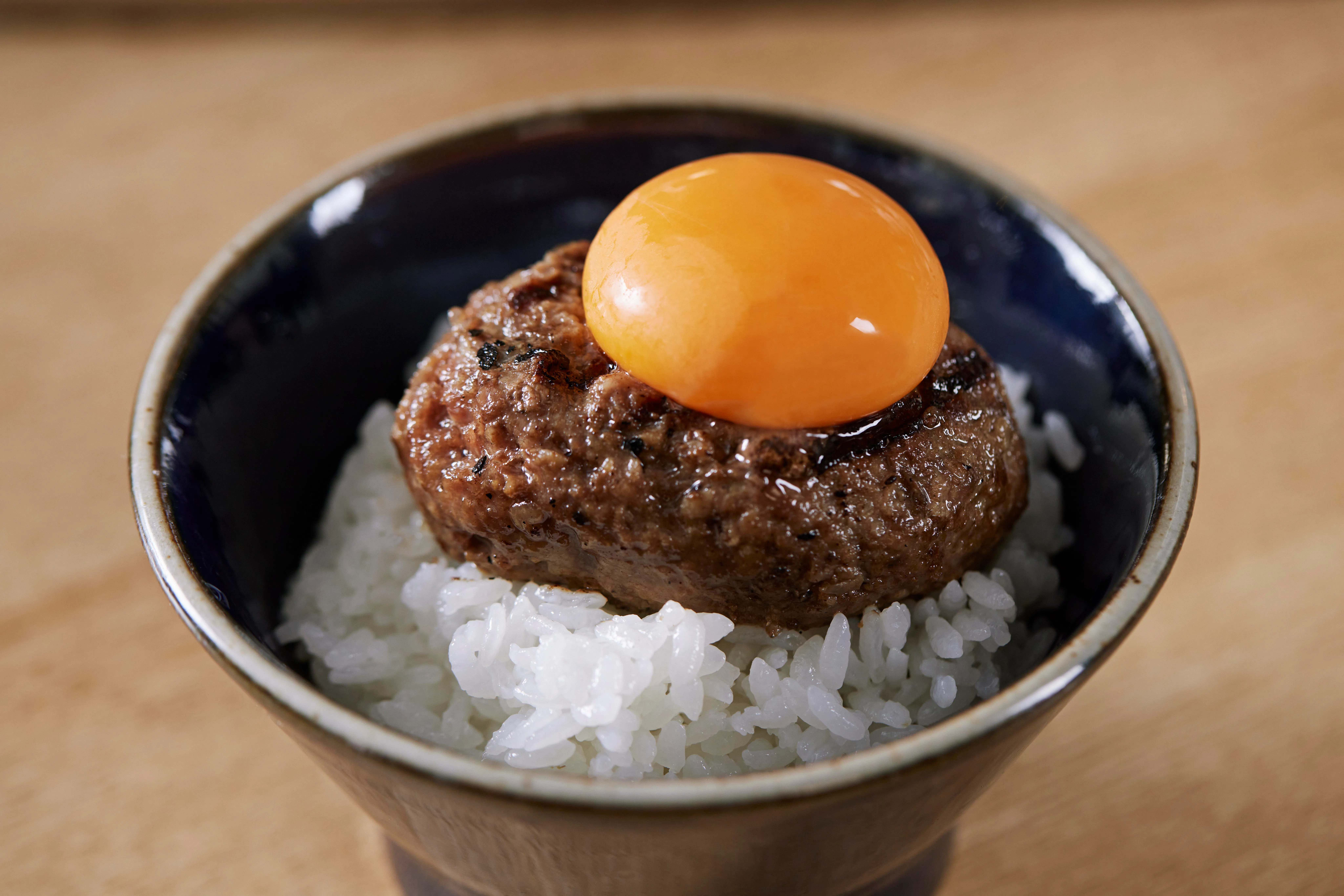 食客可将生鸡蛋打在饭上做成汉堡排生蛋拌饭，享受蛋黄与肉汁交融的滋味。（餐馆提供）