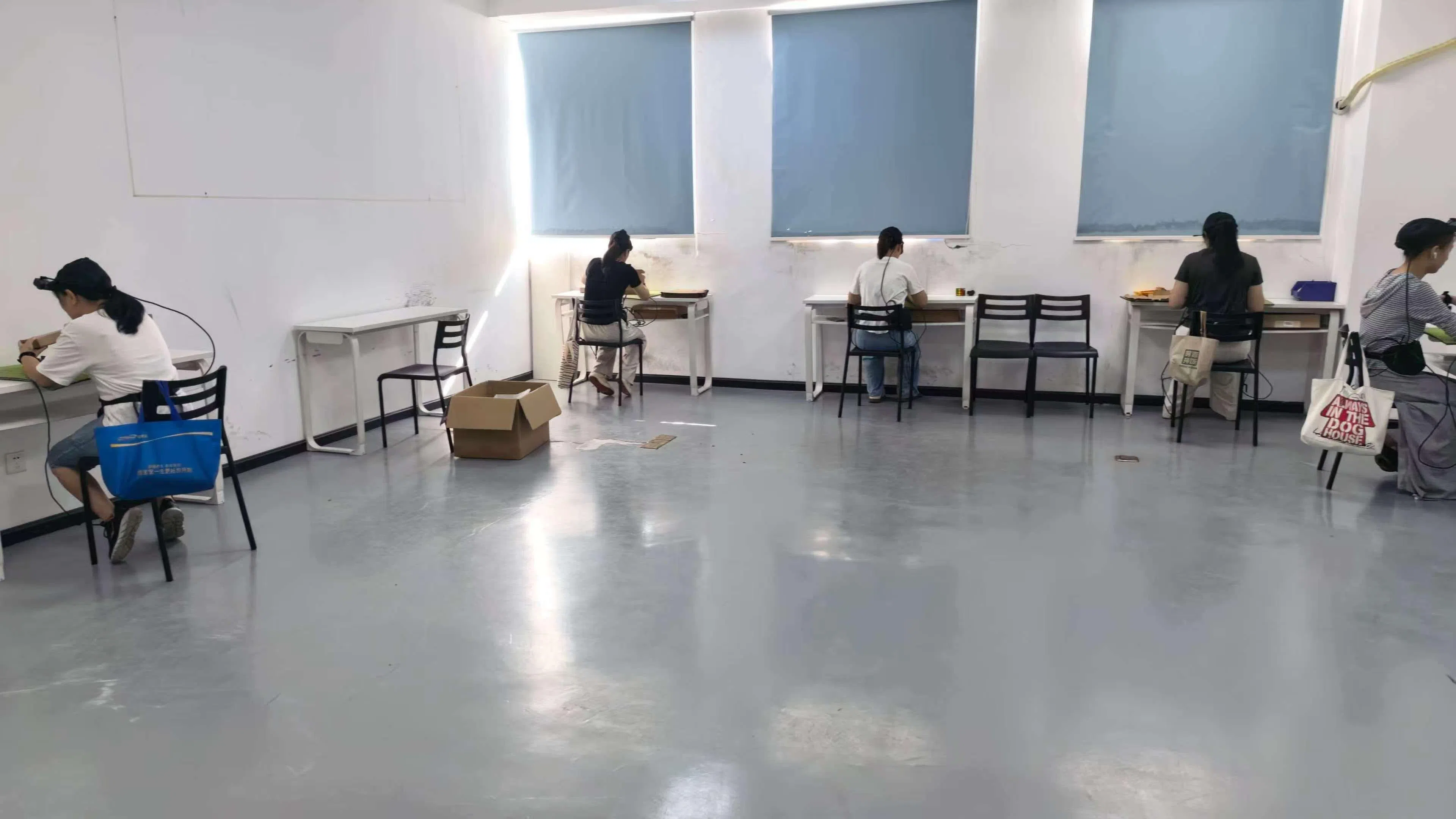 数采员坐在工位前，反复进行桌面物品拿取、整理等操作，用头戴设备记录手部动作。（受访者提供）