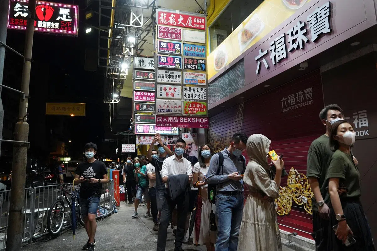 大批香港市民今天凌晨排队购买最后一期的香港《苹果日报》。（路透社）