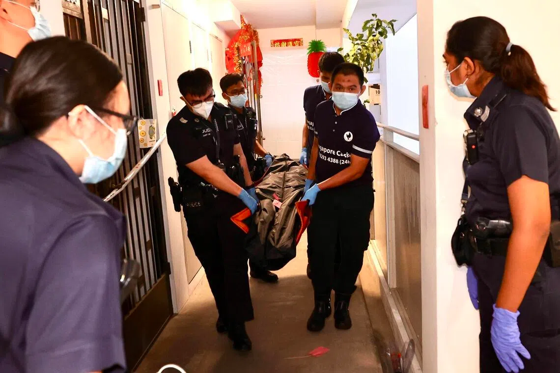 仵作抵达现场，先后将两名死者的遗体搬上黑车。（邬福梁摄）