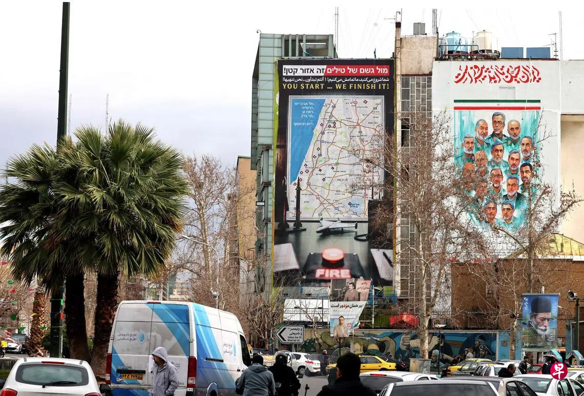 Image 16: 2月9日，德黑兰的巴勒斯坦广场竖立着一块巨大的广告牌，上面展示了以色列特拉维夫潜在目标的地图，以及“你们先动手，我们收拾残局！”的警告标语。 （法新社）