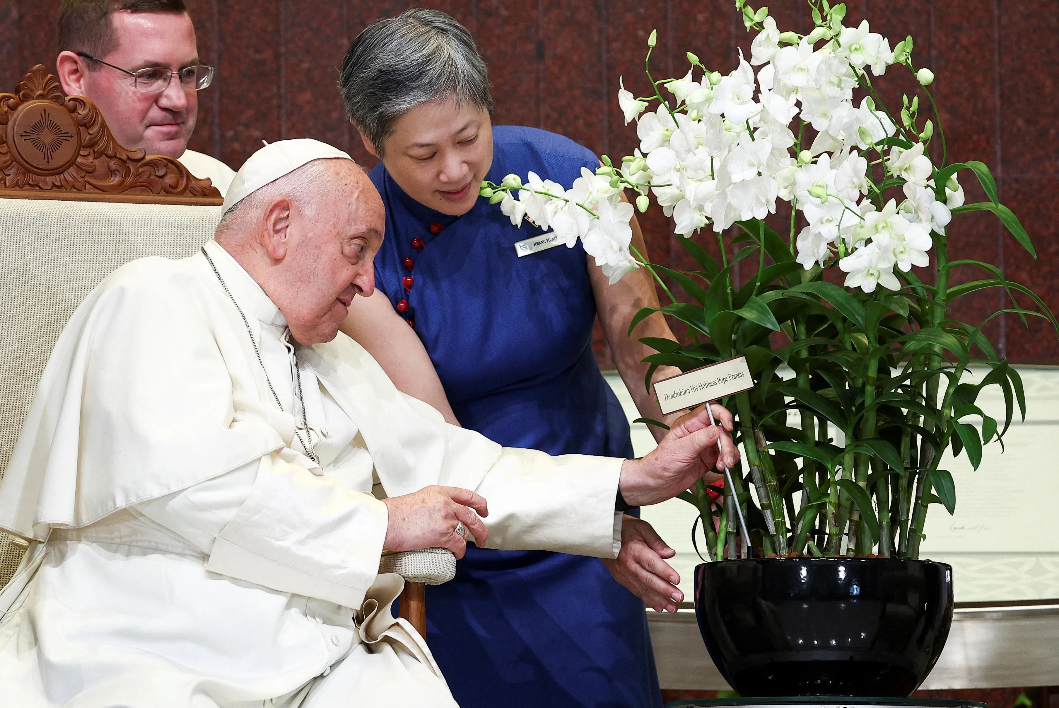 国家公园局局长黄攸宁（右一）在国会大厦，向教宗方济各介绍以他命名的“教宗方济各石斛兰”配种胡姬花。（路透社）
