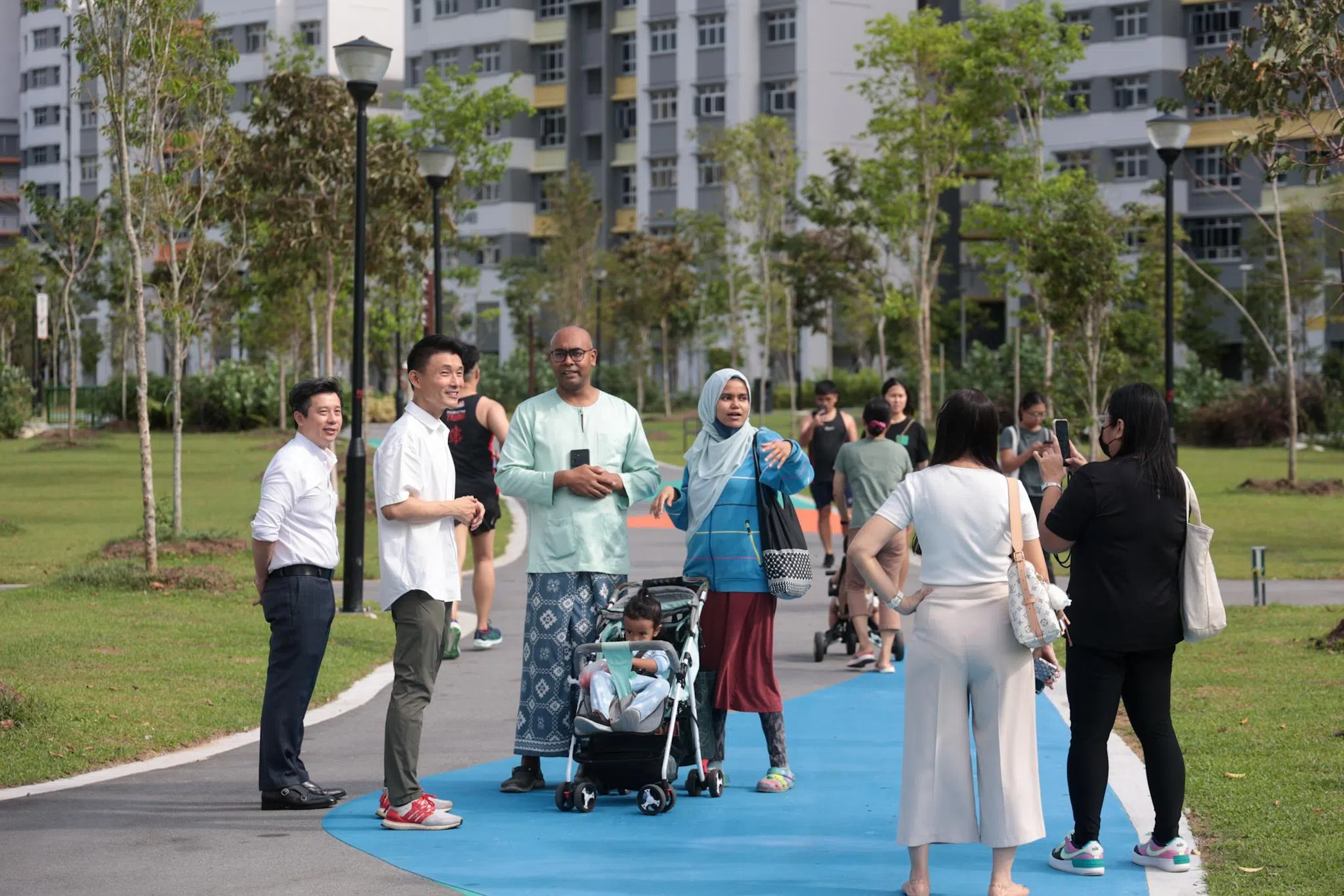 淡滨尼区议员马炎庆（左二）前往新开放的淡滨尼林荫大道公园西园参观，不少居住在附近的居民已在公园里散步休闲，并与马炎庆分享他们对西园的感受。（张俊杰摄）