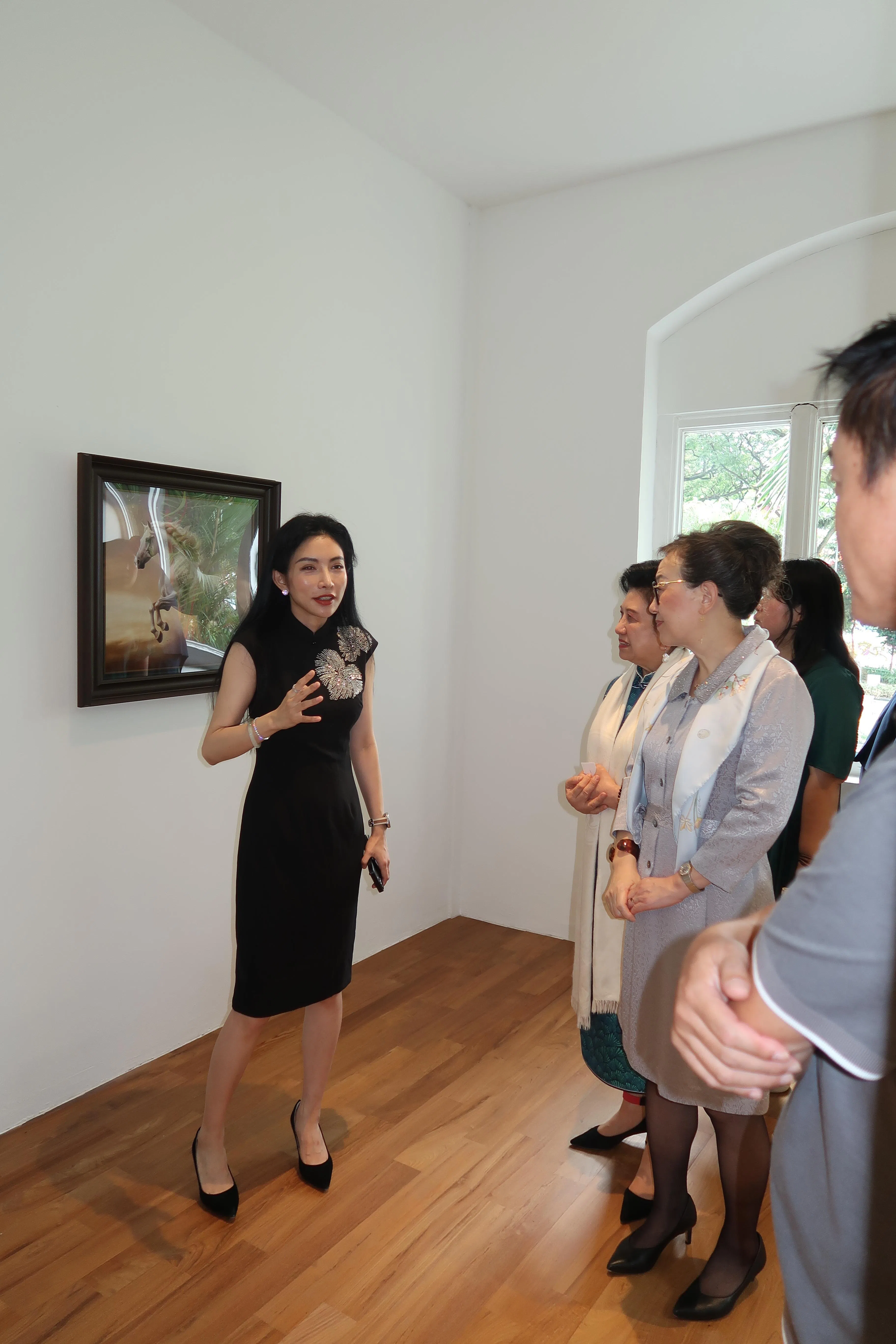 画家米巧铭在画展开幕礼上向嘉宾讲解作品。（巴音基金会提供）