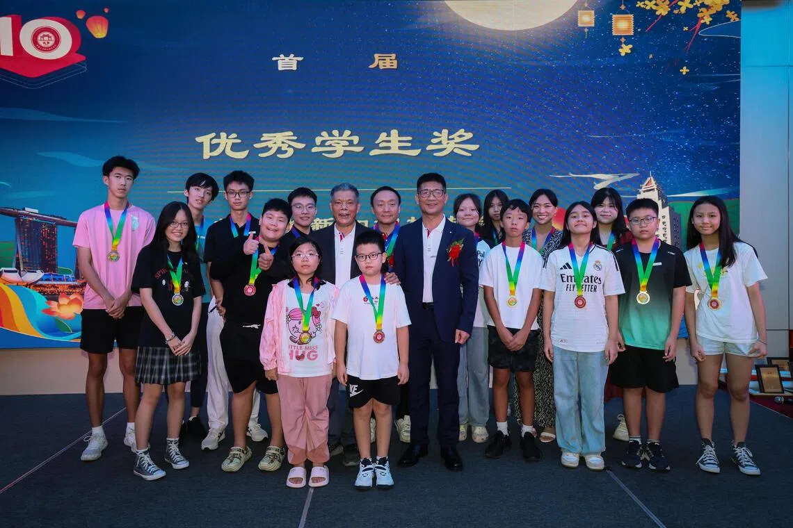 晚宴上宣布设立“优秀学生奖”，鼓励年轻学子在诚毅精神下继续前行。首届优秀学生奖得主与林清其会长（中间别胸花者）等人合影留念。（龙国雄摄）